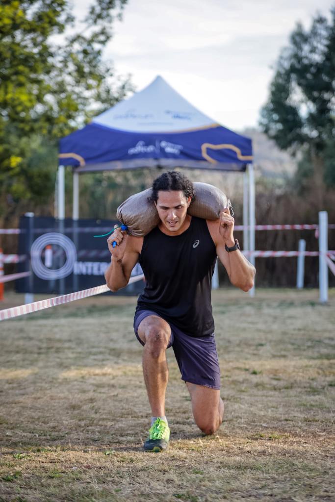 Man lunging with sandbag on his shoulders